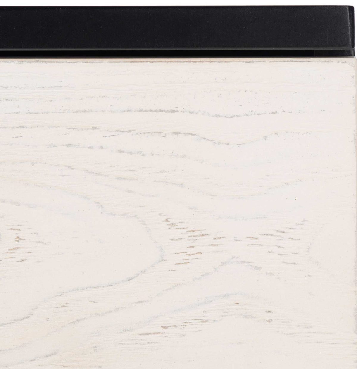 Whitewashed wood grain softens the crisp edge of the black tabletop.