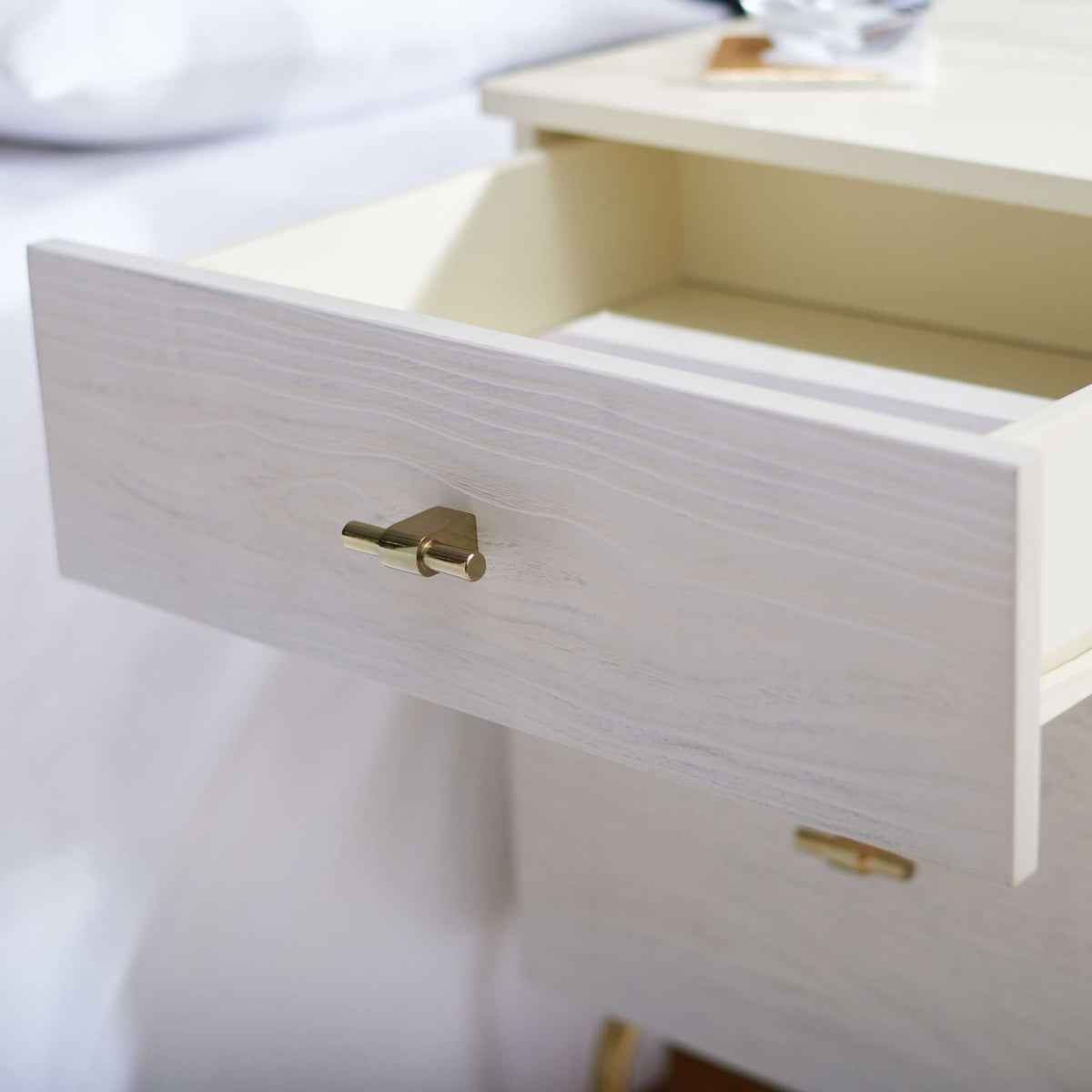 The upper drawer slides out to reveal a roomy cream interior for bedside storage.