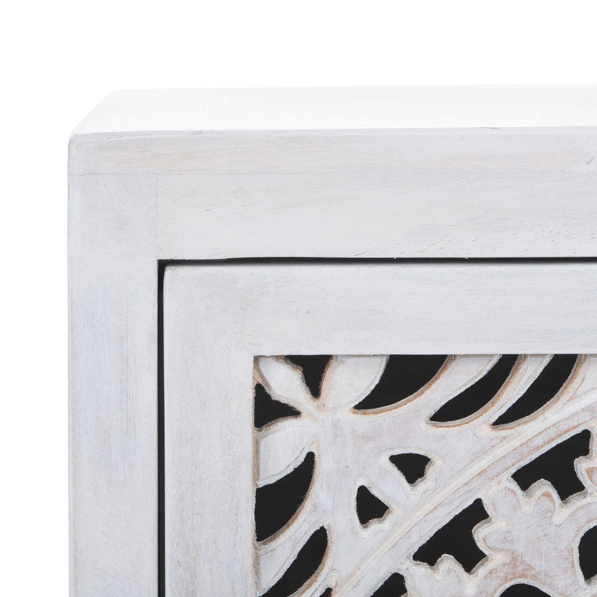 Delicate floral cutouts bring intricate texture to the whitewashed cabinet door