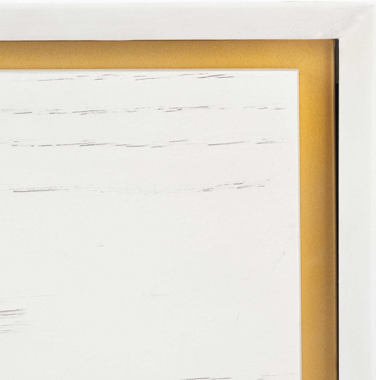 Brass-colored inset trim borders the whitewashed drawer front and its subtle wood grain