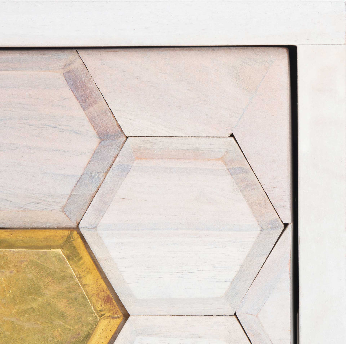 Carved hexagons reveal subtle wood grain, with a bright brass accent adding contrast to the drawer.