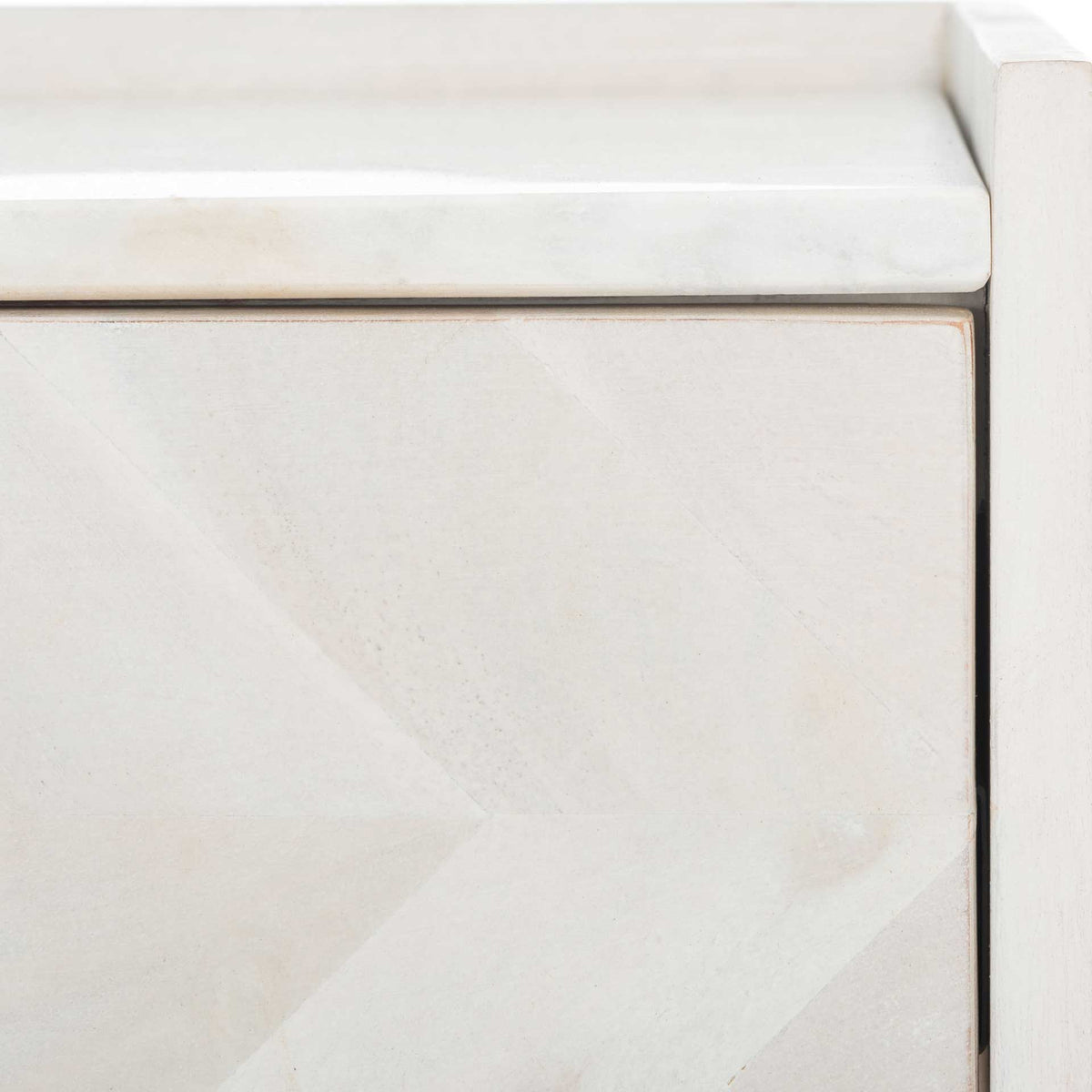 The white marble-look top contrasts with softly patterned whitewashed wood on the drawer and frame.