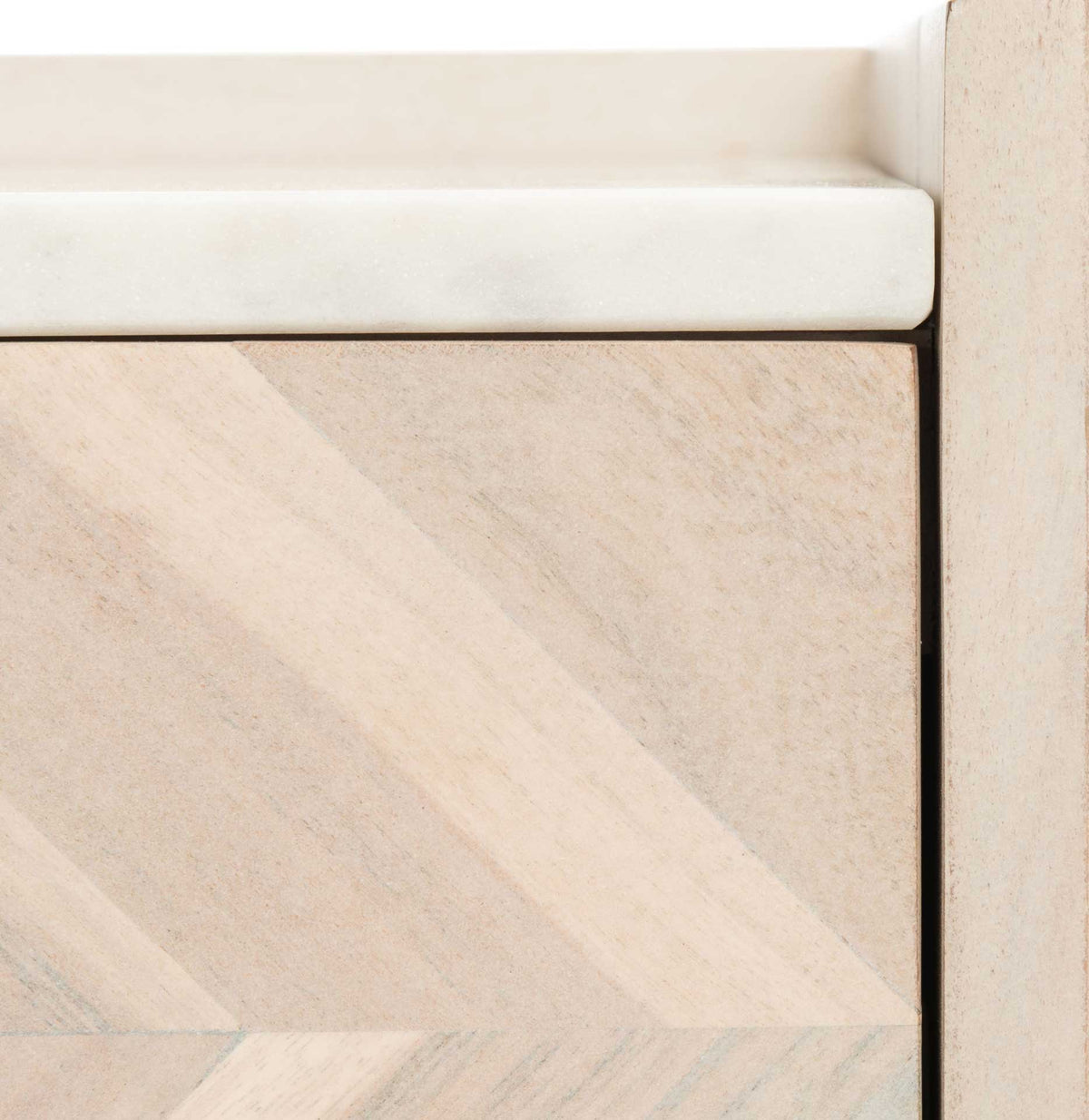 Diagonal wood grain on the whitewashed drawer meets the white marble-look top and upright frame.