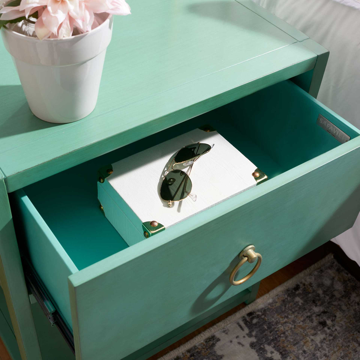 A roomy turquoise drawer holds accessories, while its gold ring pull adds a polished accent.