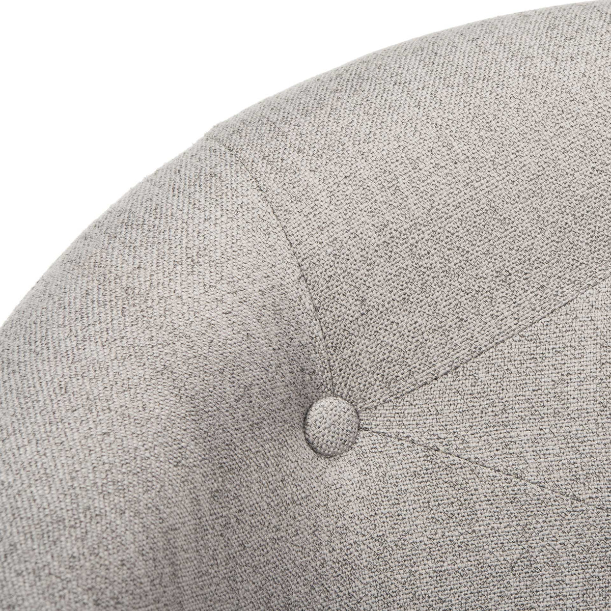 Woven gray linen, radiating seams, and a fabric-covered tufting button add tailored texture