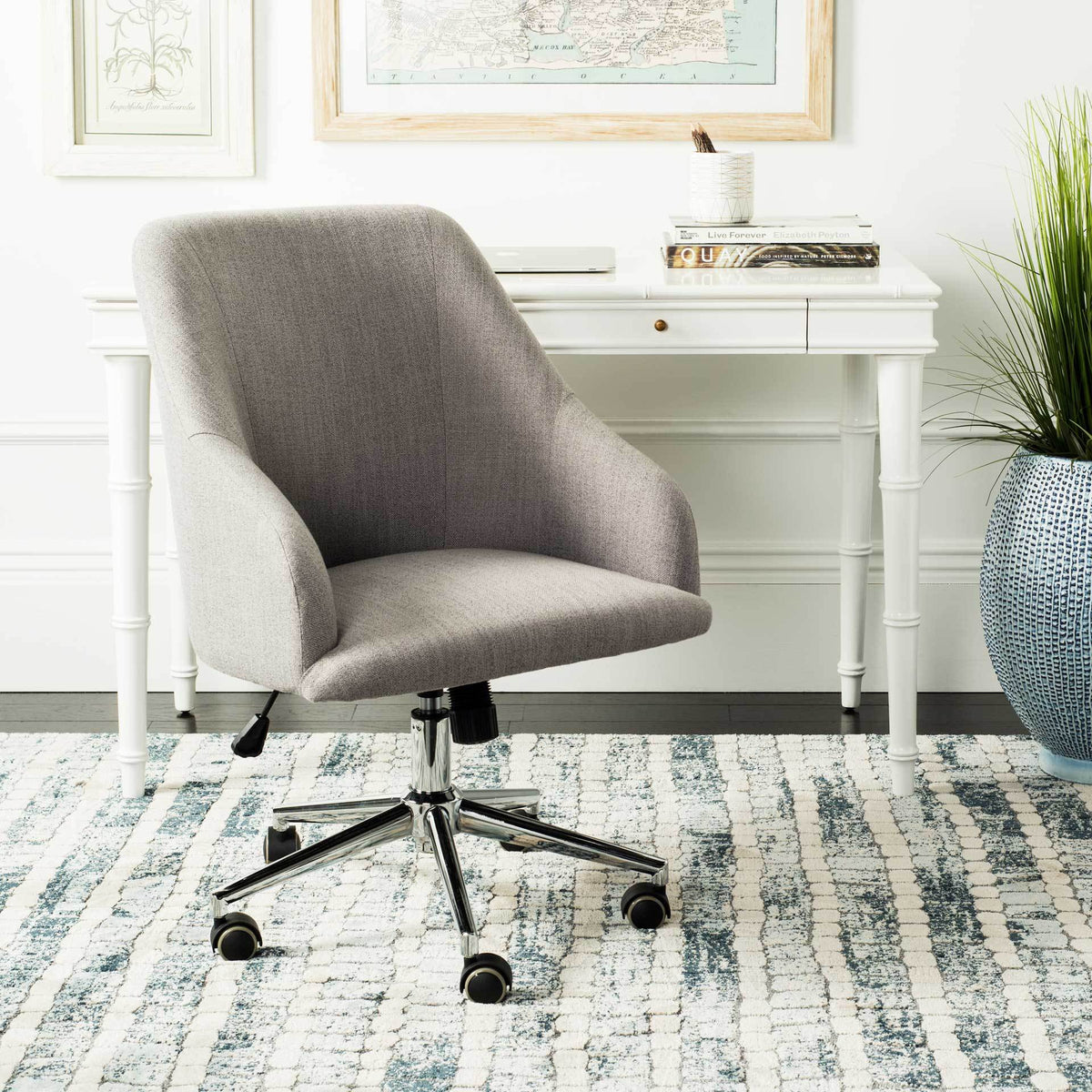 A gray upholstered swivel chair brings soft curves and a rolling chrome base to a home workspace