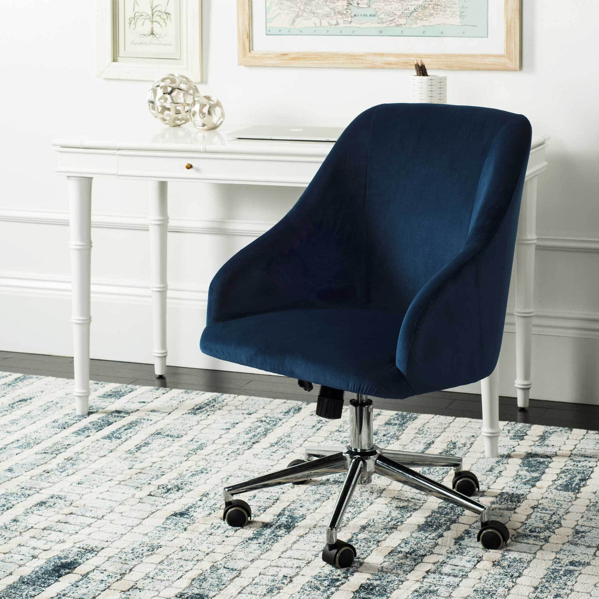 A navy velvet swivel chair adds rich color and plush comfort beside a white home office desk