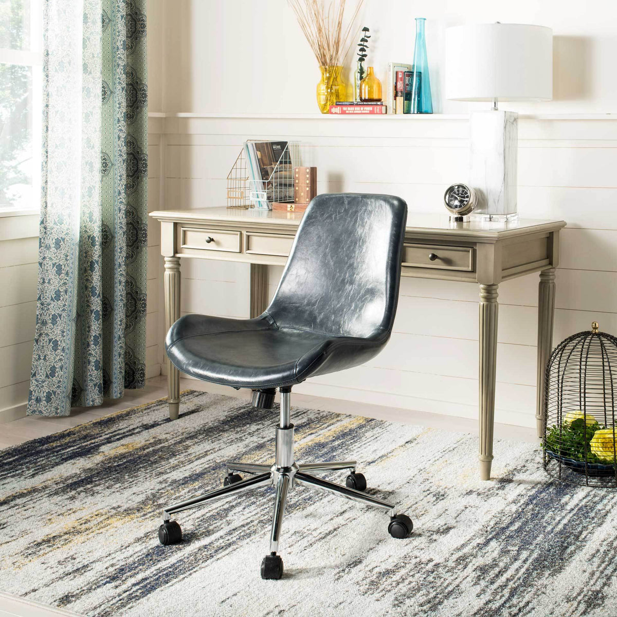 Sleek dark gray faux leather and polished chrome casters add modern style to a home office