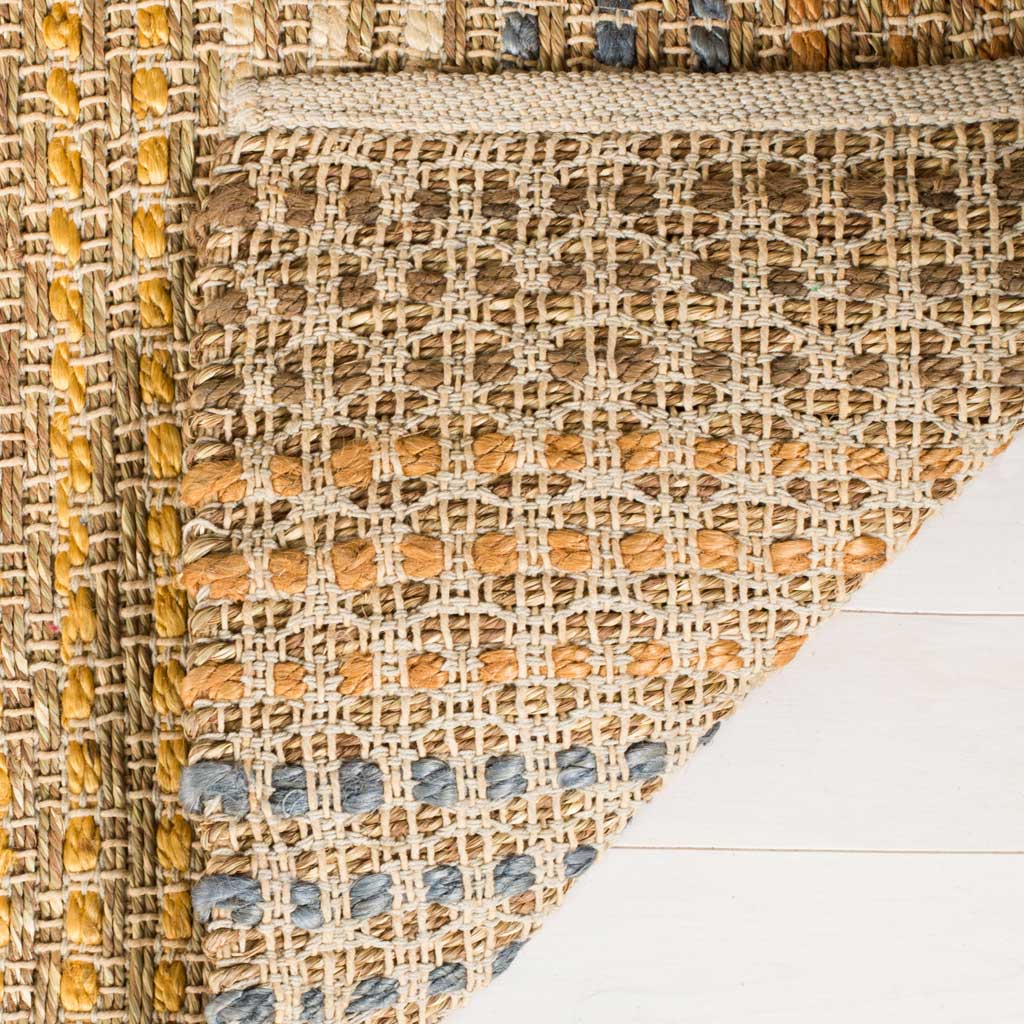 A turned-up corner reveals the rug's woven backing and natural jute fibers.