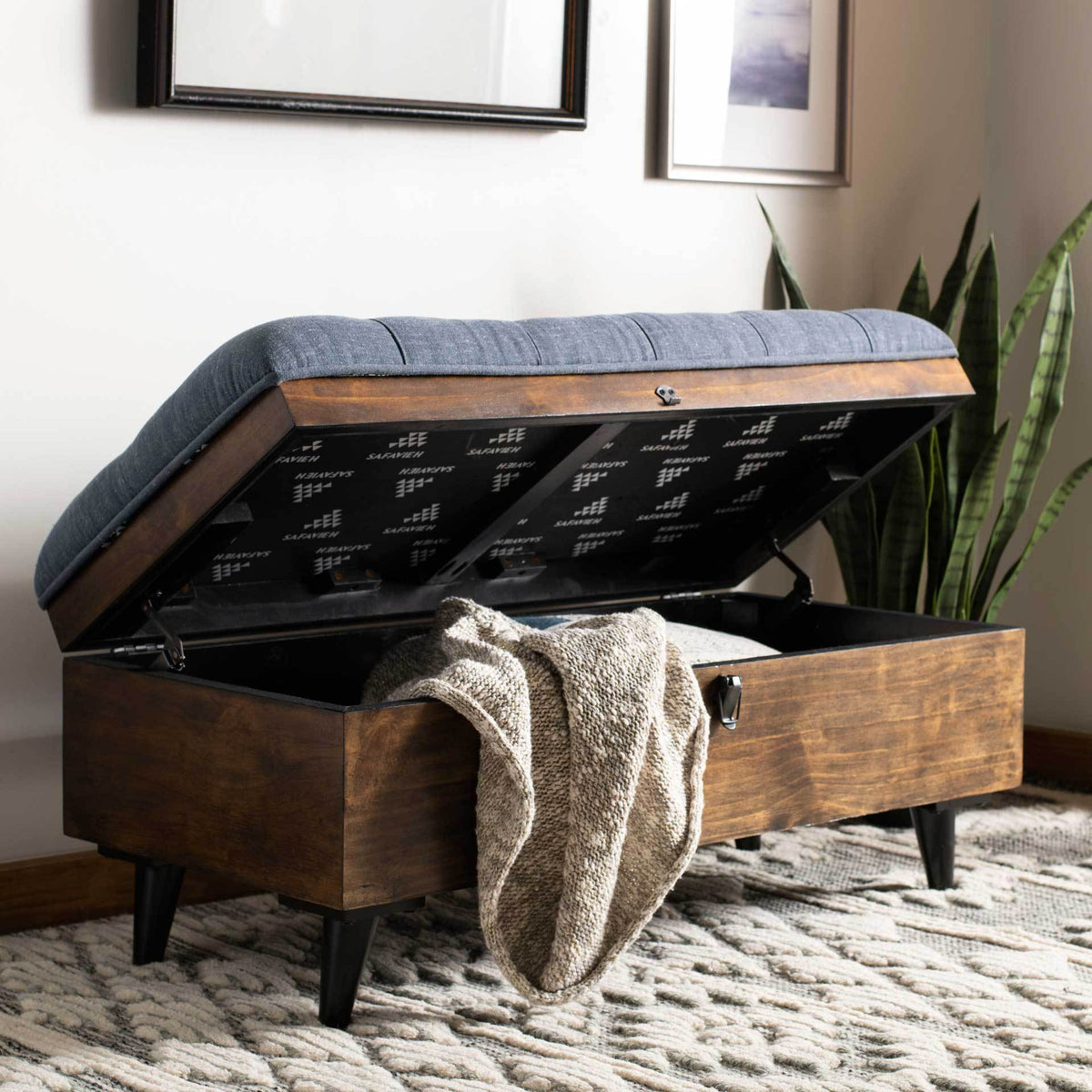 The tufted navy lid lifts to reveal ample storage for blankets and living room essentials.