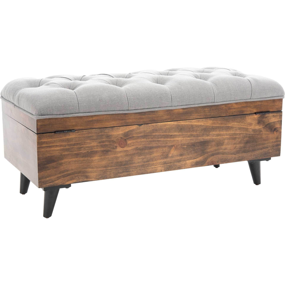Warm wood grain surrounds the chest beneath a plush gray tufted cushion.