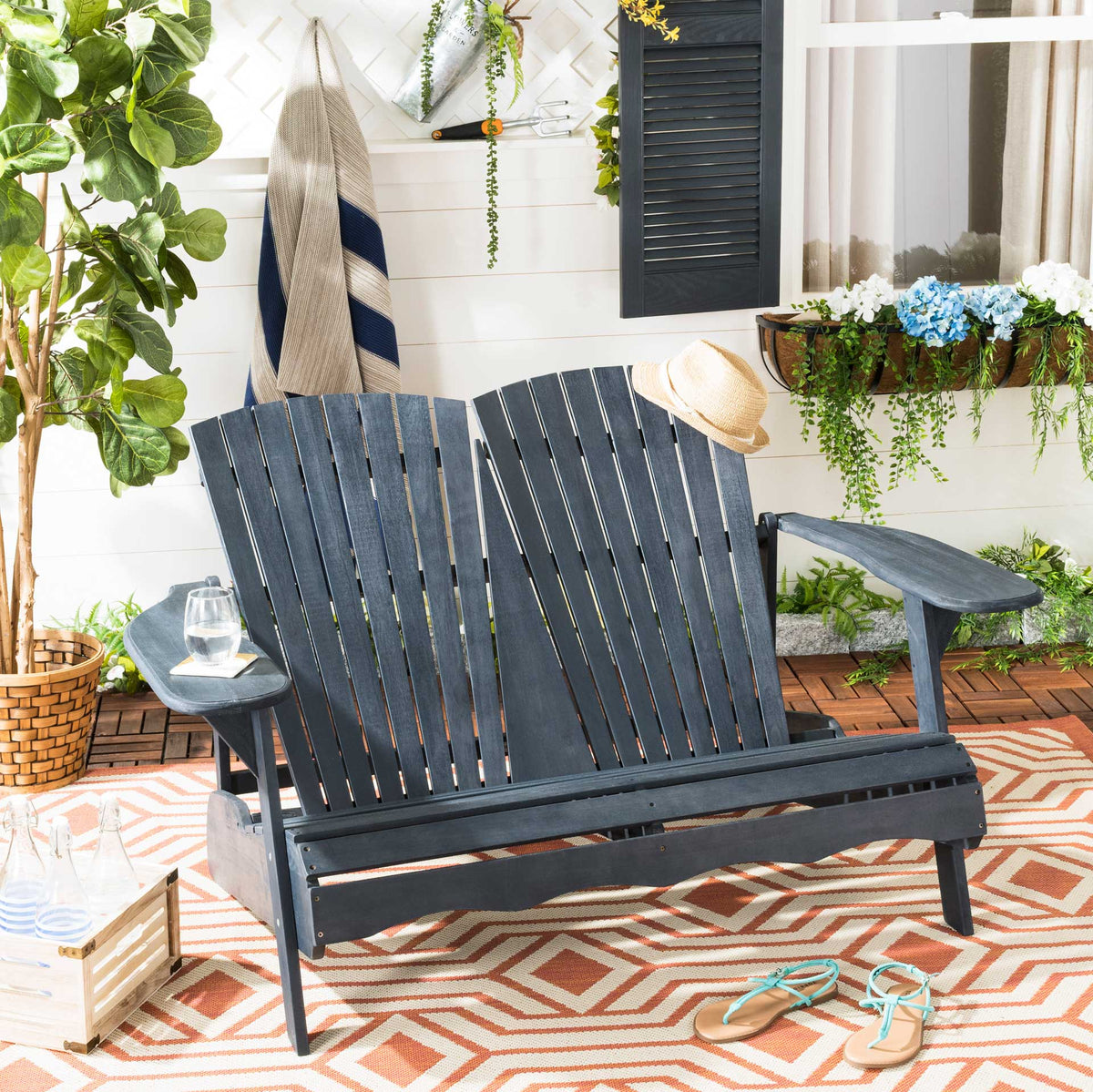 Dark slate gray Adirondack loveseat with a low seat and broad arms for relaxed patio lounging