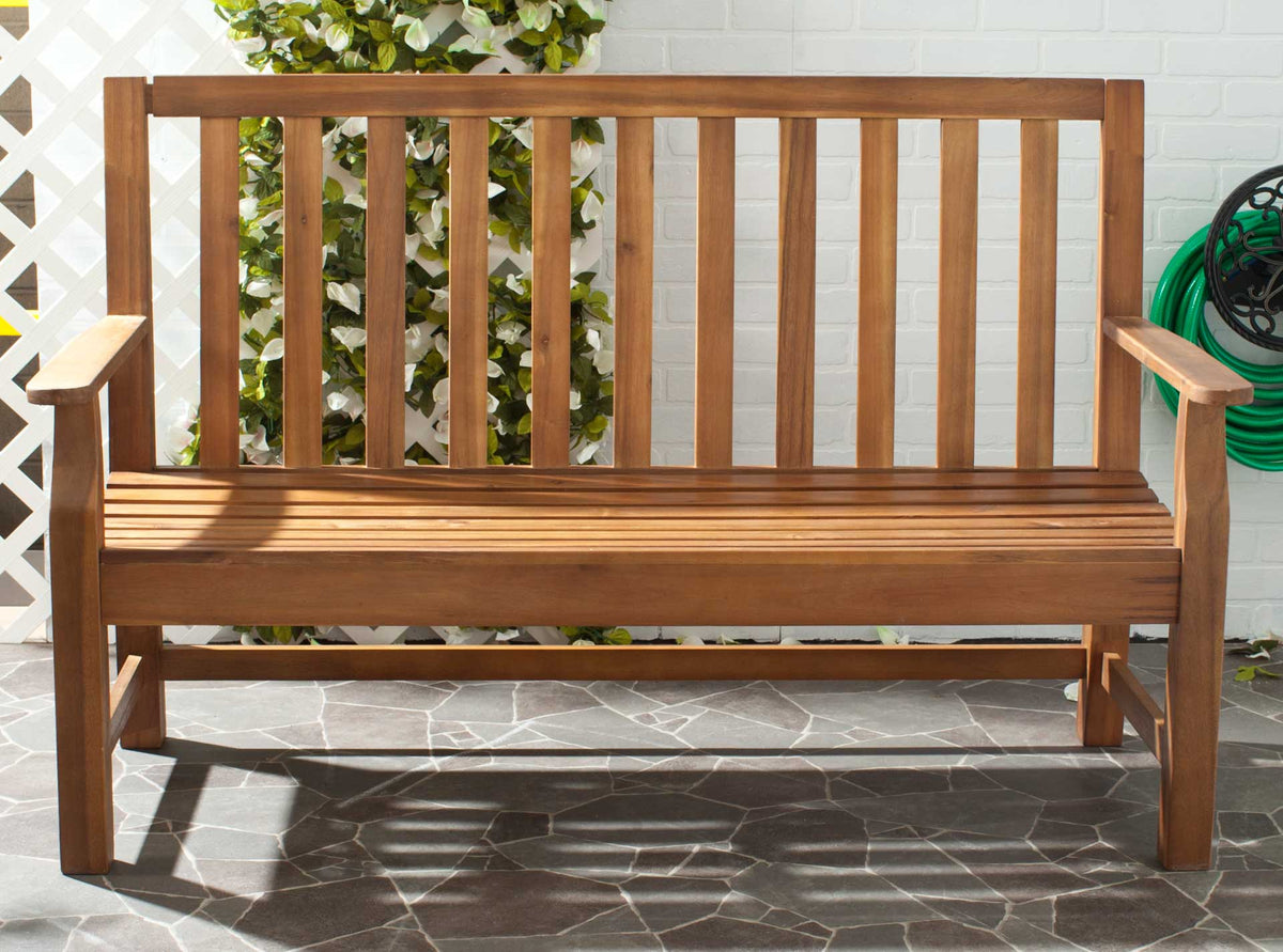 Natural wood bench brings warm slatted seating to a sunlit patio with leafy greenery.
