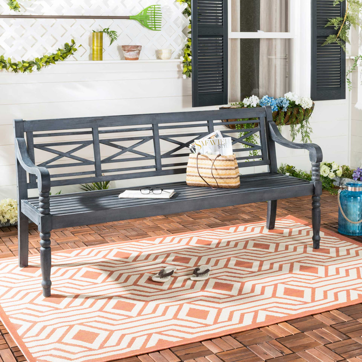 Dark slate gray lattice-back bench adds timeless wood seating to a colorful patio