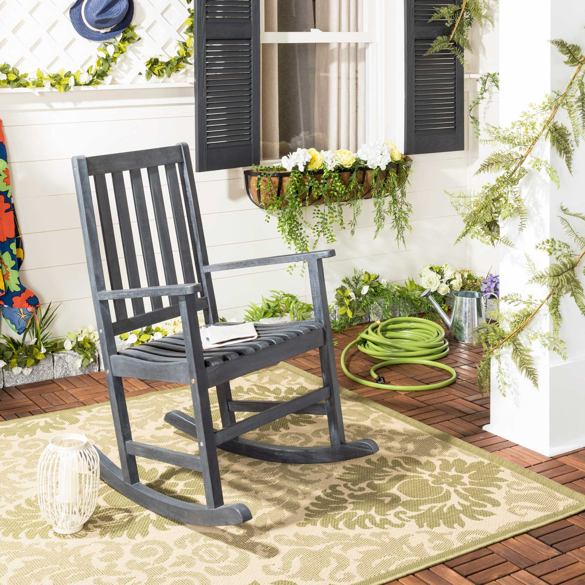 Dark slate gray slatted rocker adds a relaxed touch to an inviting garden porch.