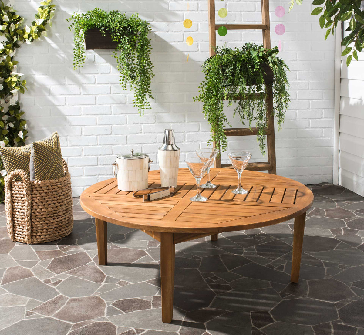 Round slatted wood table offers a welcoming centerpiece for drinks and conversation outdoors