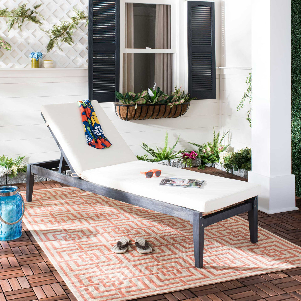 A dark slate gray chaise with soft beige padding brings relaxed comfort to a patio retreat.