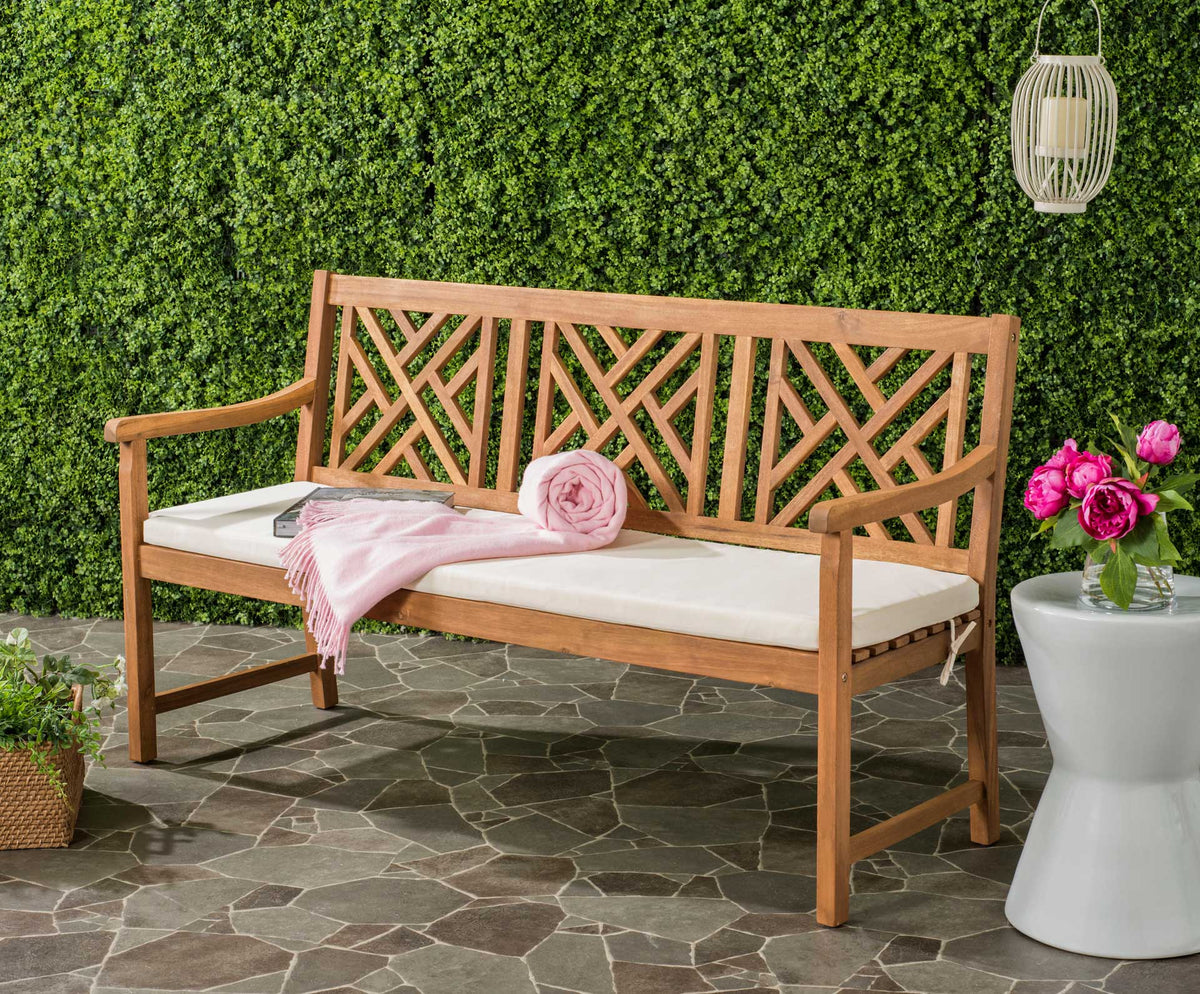Natural acacia and a beige cushion lend warmth to this geometric bench on a garden patio