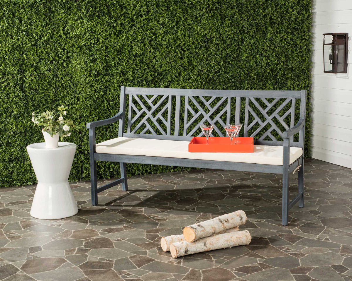 Ash gray lattice-back bench and beige cushion bring classic seating to a stone patio
