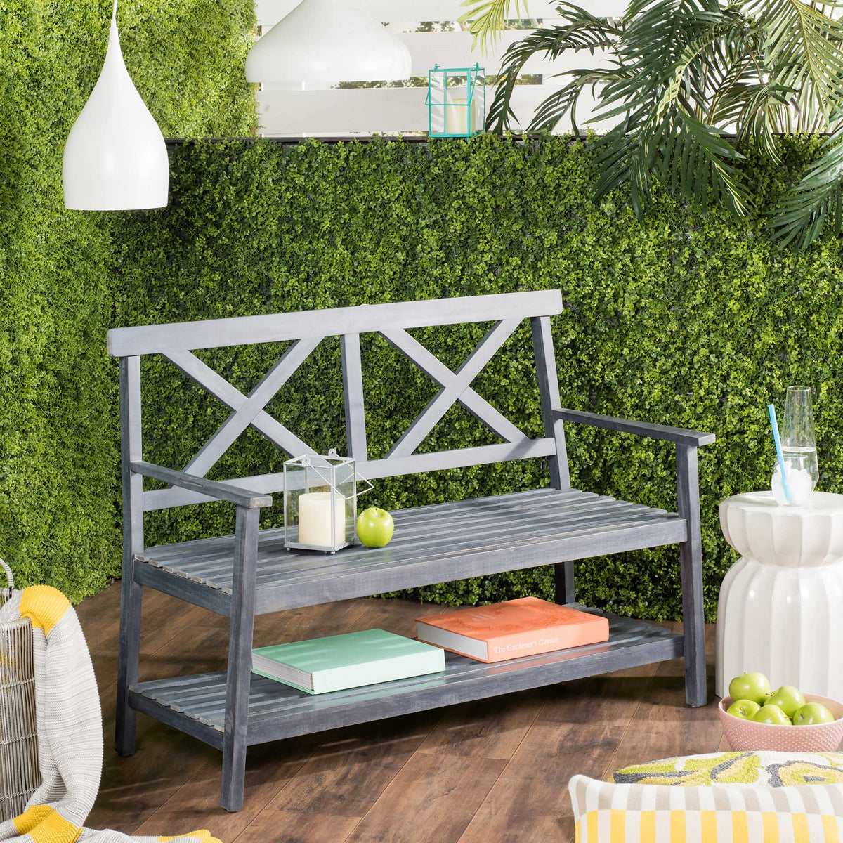 Dark slate gray outdoor bench offers a roomy slatted seat and shelf space for books and patio essentials.