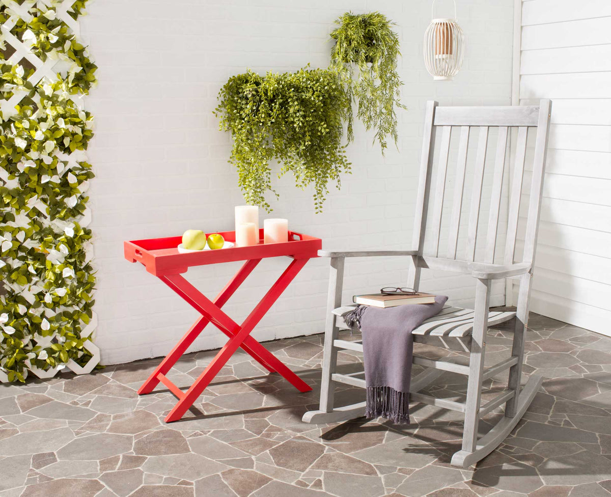 Gray-washed slatted rocking chair offers an inviting place to unwind on a leafy patio