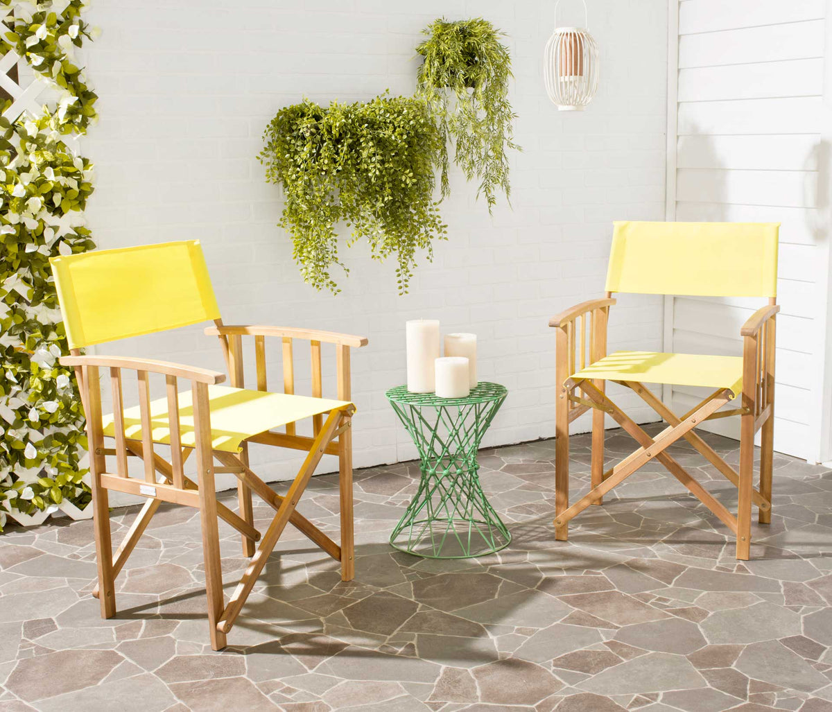 Two bright yellow fabric chairs offer casual seating beside greenery on a paved patio