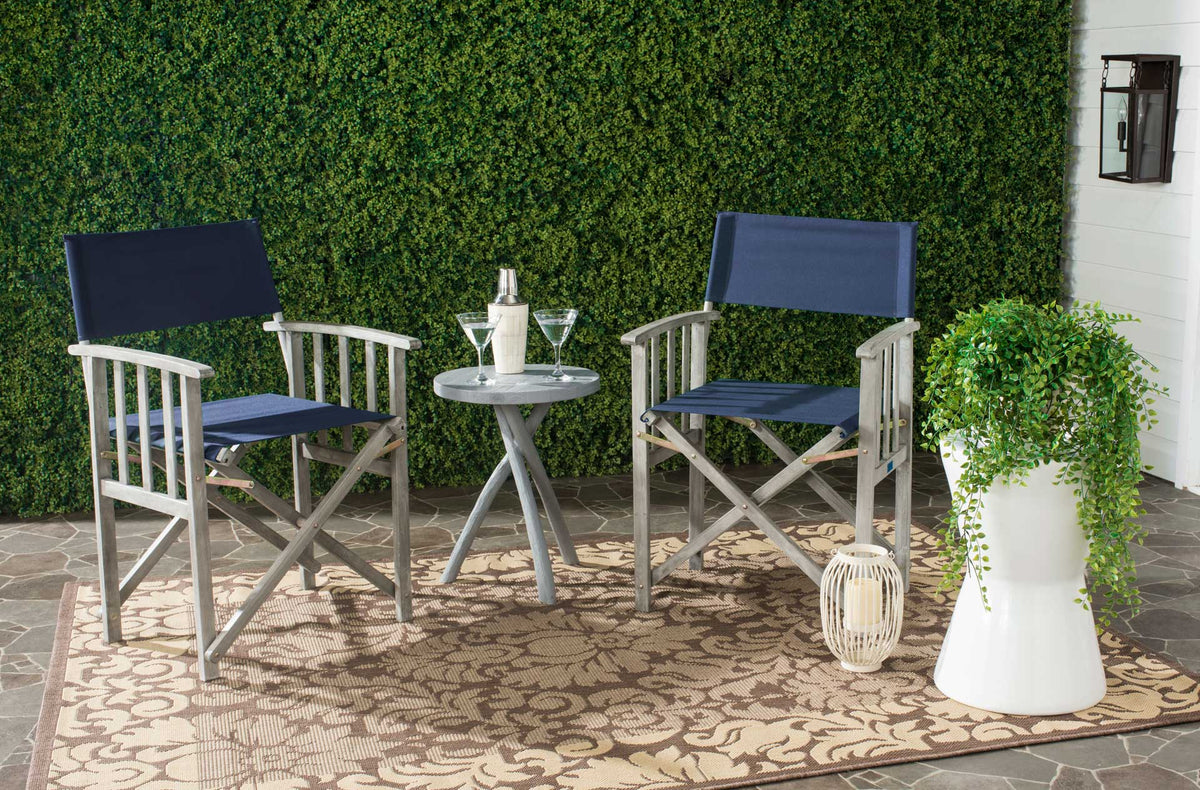 Two navy sling chairs with gray-washed wood arms make a welcoming patio seating pair