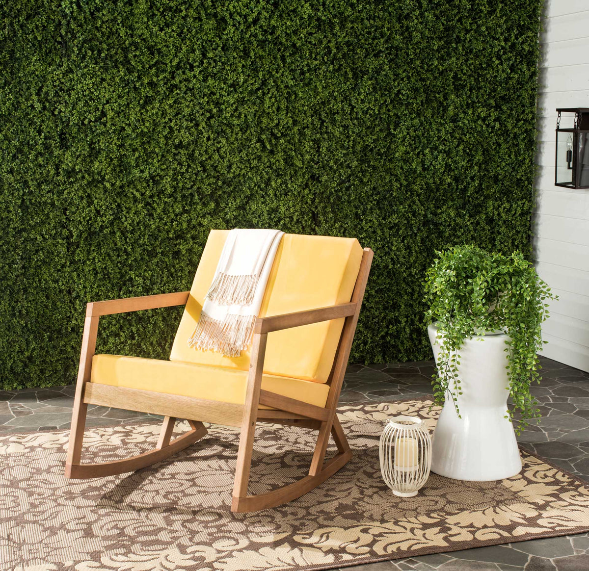 Warm wood and sunny yellow cushions create an inviting retreat on a garden patio.