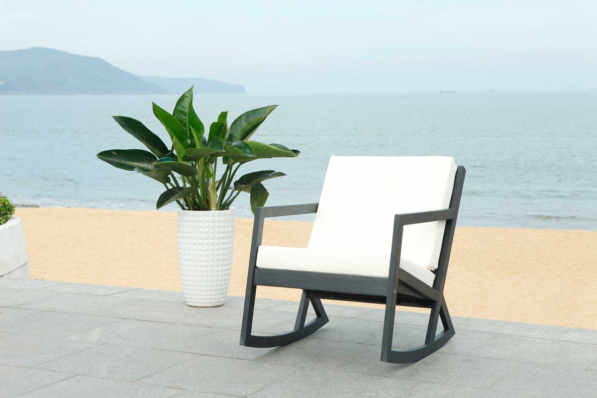 Black curved runners and light cushions bring laid-back comfort to a coastal patio.