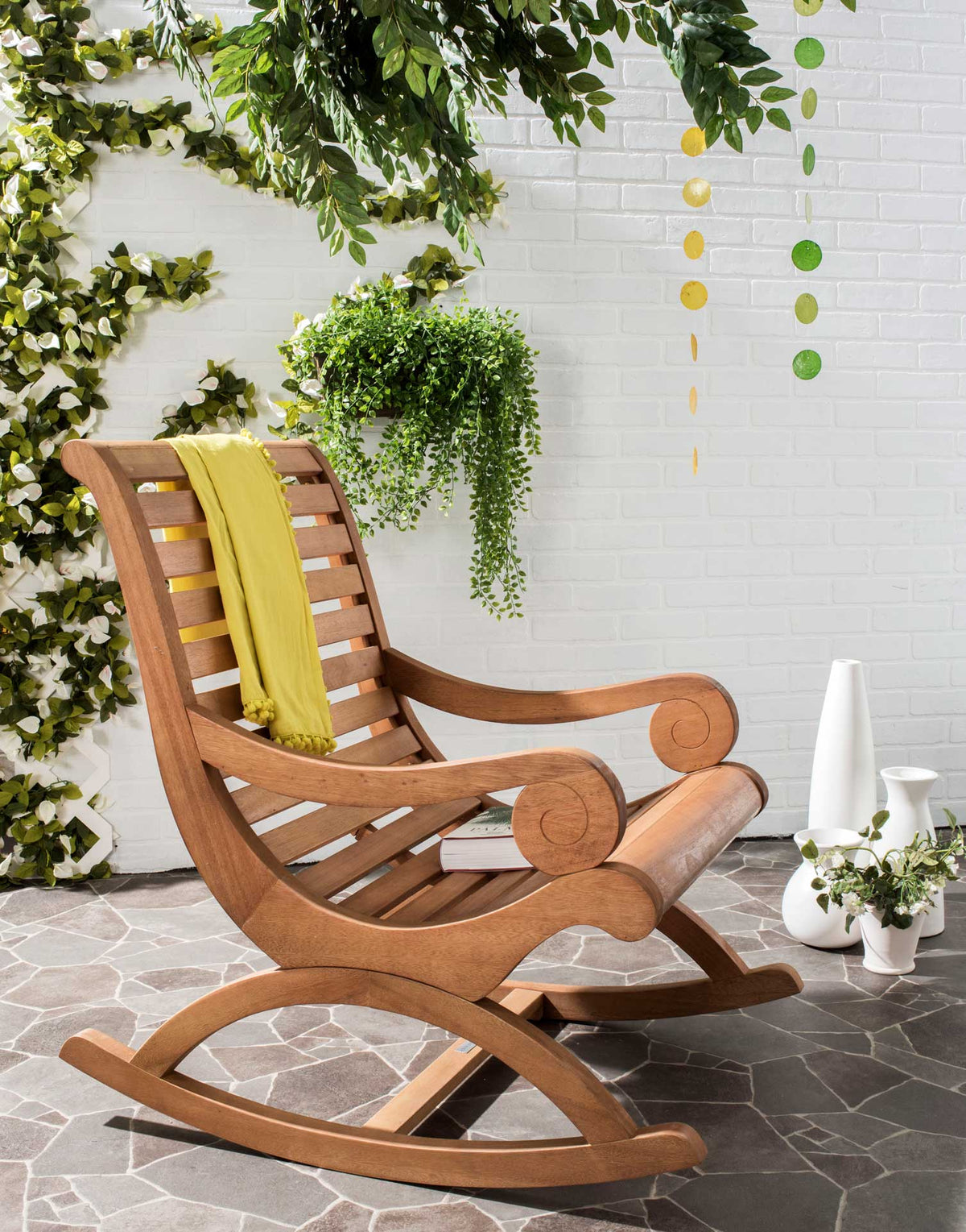 Warm wood rocking chair with sculpted scroll arms and curved runners suits a leafy patio
