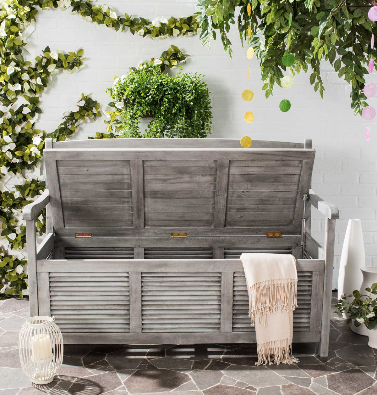 The gray bench's raised seat reveals roomy storage for throws and other patio essentials.