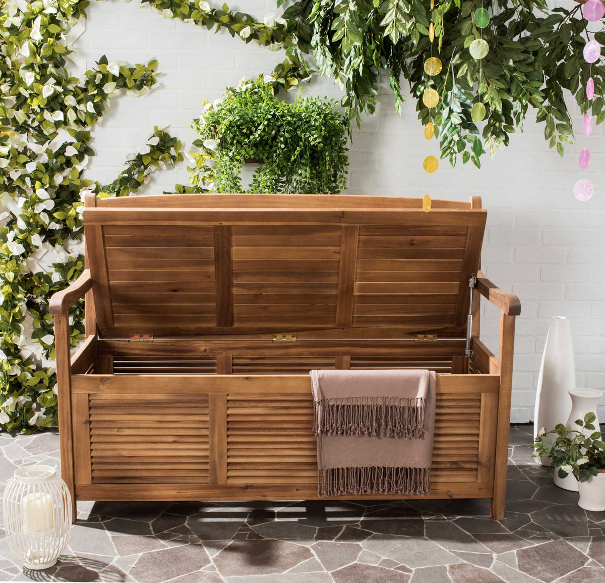 A lifted seat reveals generous storage in the natural wood bench, with a throw draped over the front.