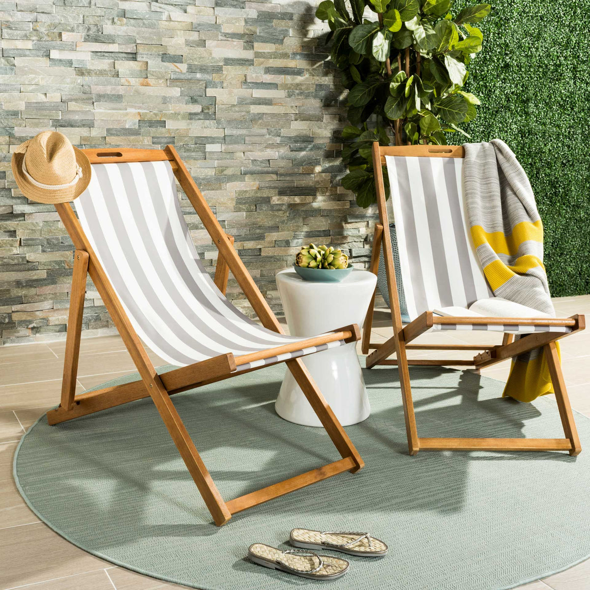 Two gray-striped sling chairs add laid-back seating and warm wood tones to a sunny patio.