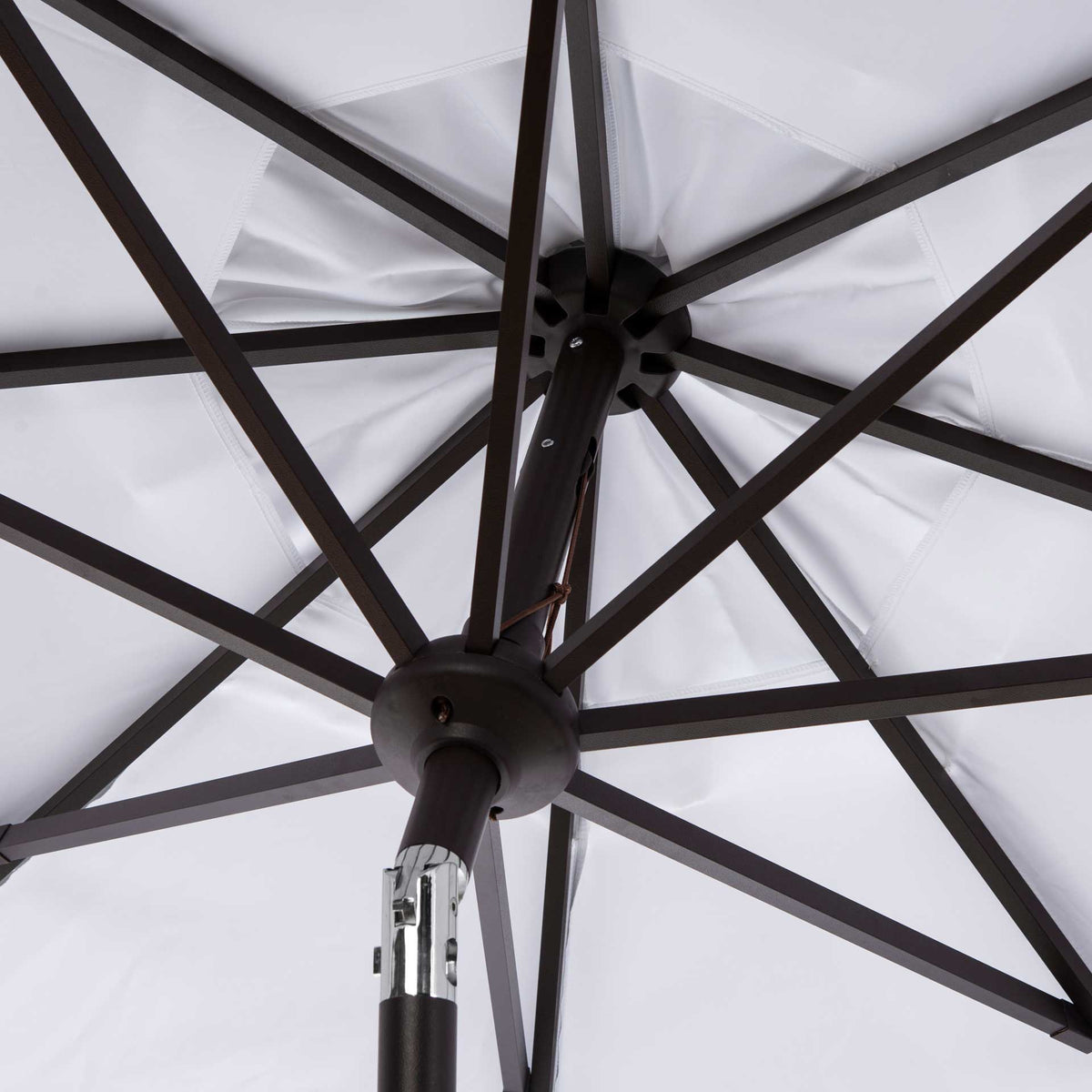 Dark metal ribs radiate beneath the white canopy from a central hub and tilt joint