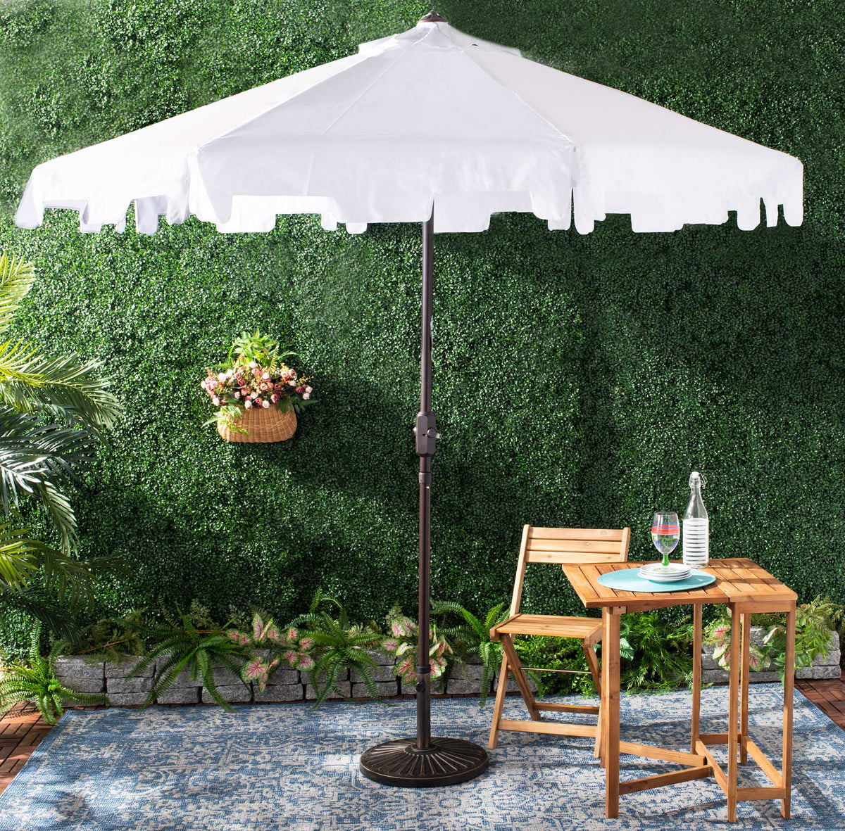 White valanced umbrella shades a garden patio table on its brown center pole