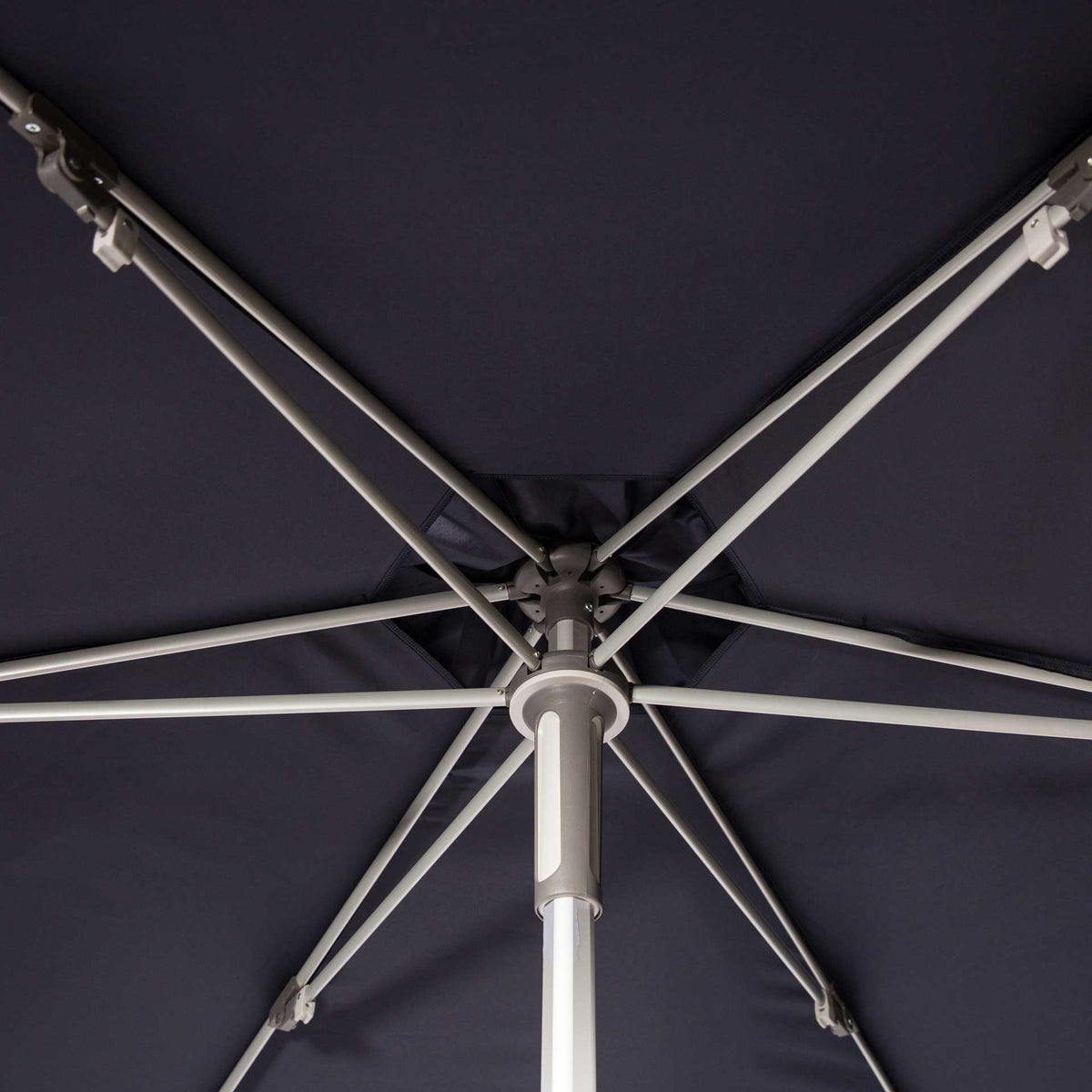 A network of metal ribs supports the navy fabric around a central hub.