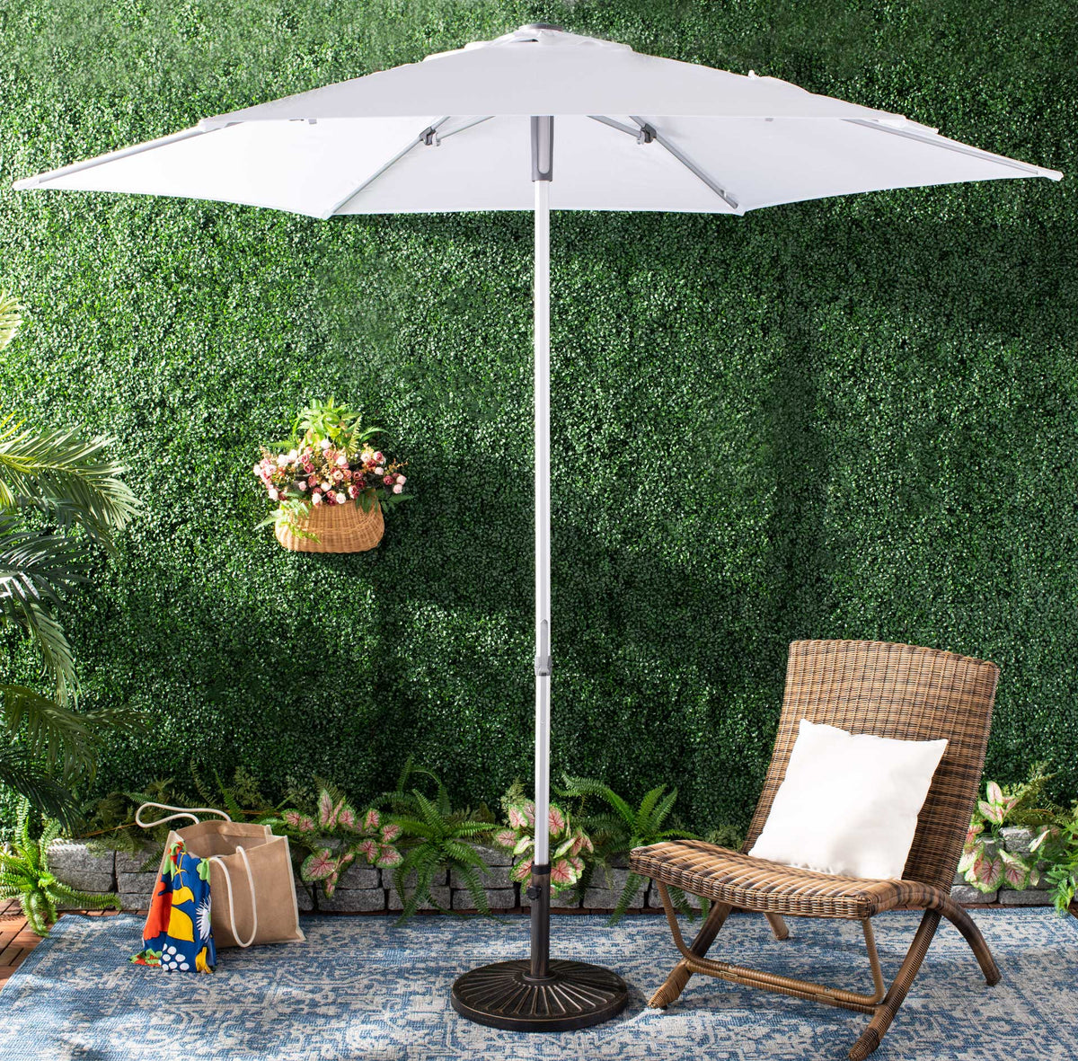 A bright white canopy shelters a garden lounge beside a wicker chair.