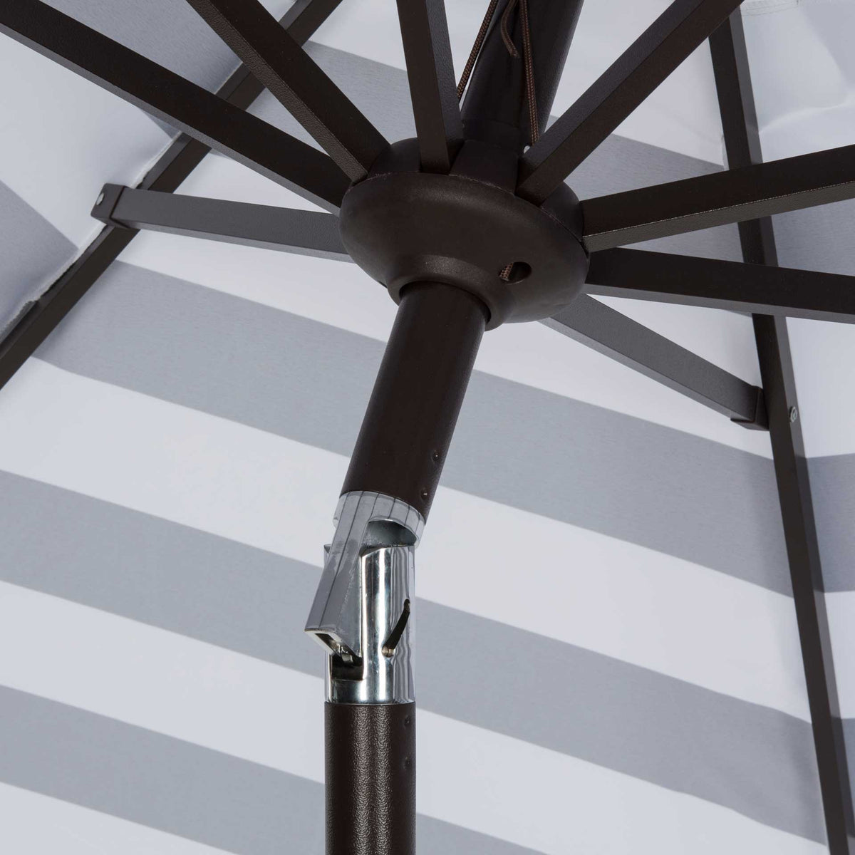 Dark metal ribs radiate from a sturdy hub above the hinged tilt joint.