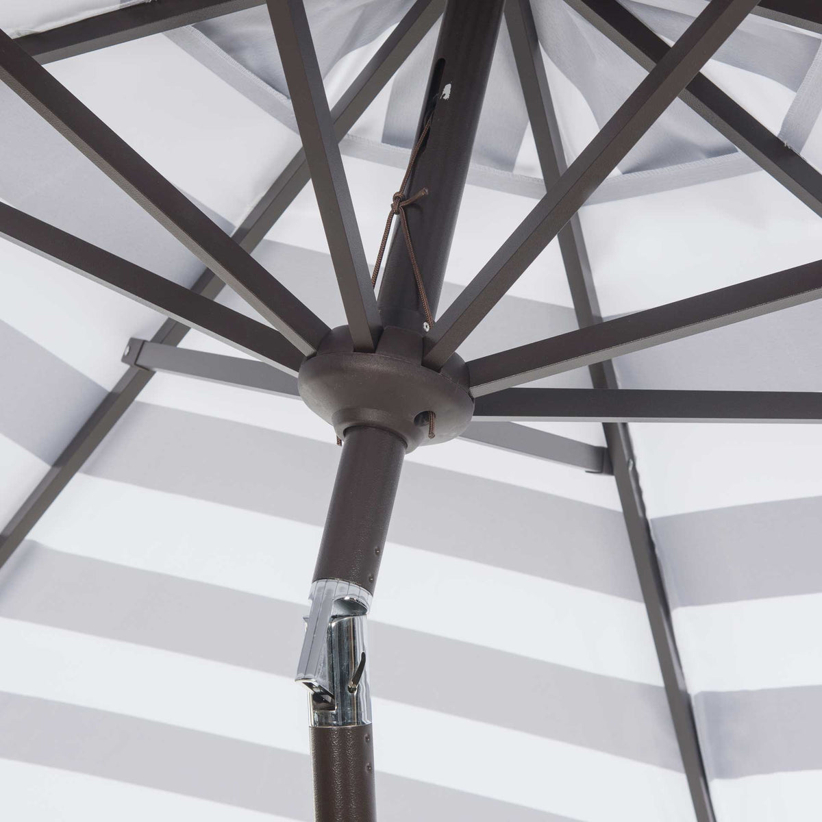 Dark metal ribs converge at a central hub above a silver tilt hinge.