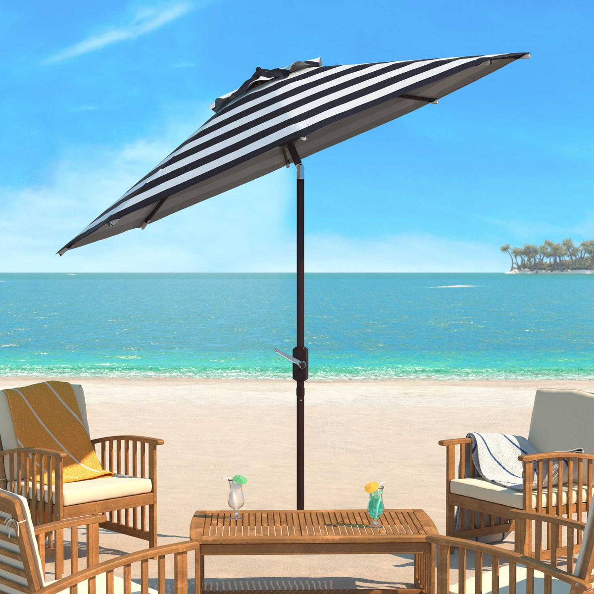 A dark striped umbrella shades a coastal patio with wooden seating.