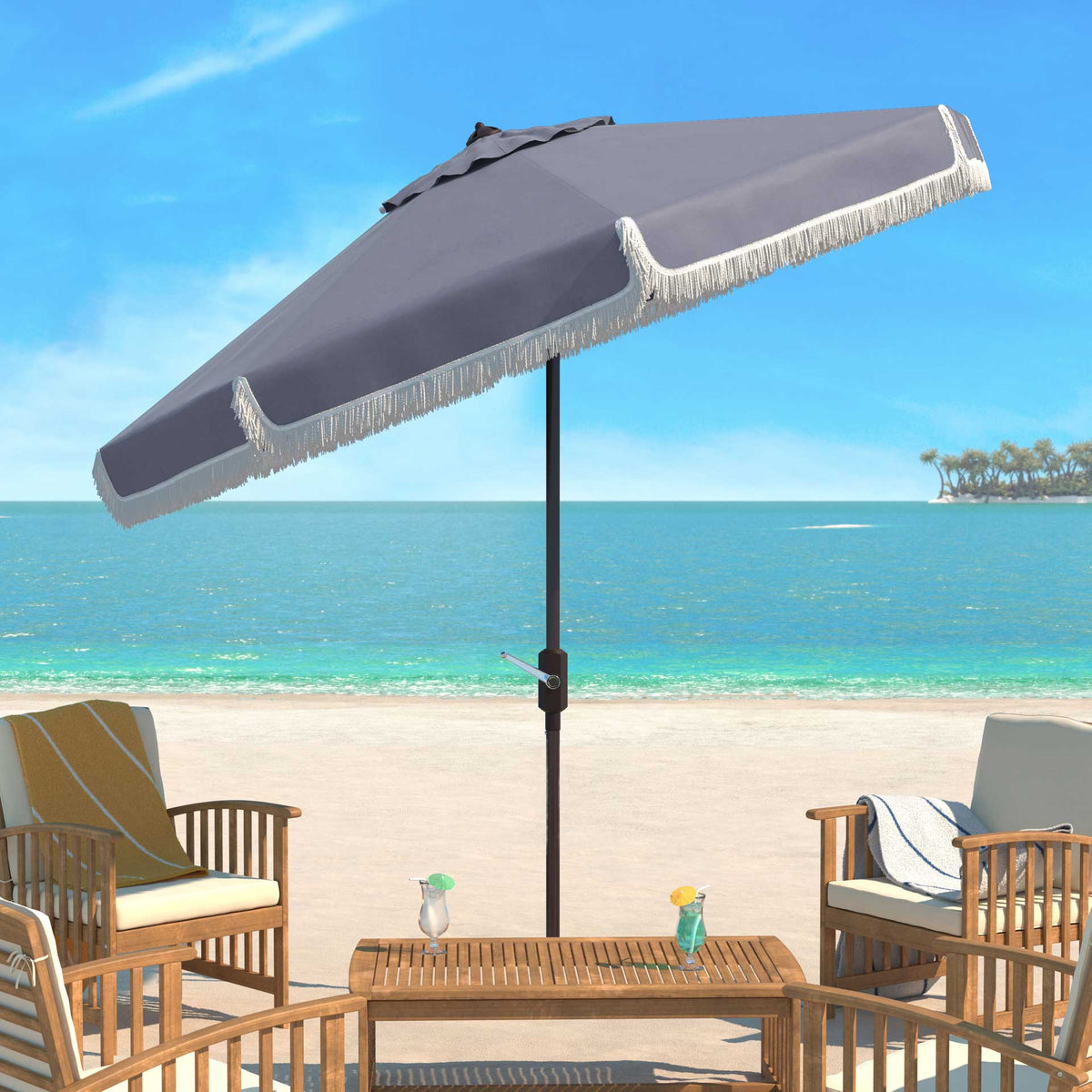 A tilted gray canopy and white fringe add shade to a seaside patio table and chairs.