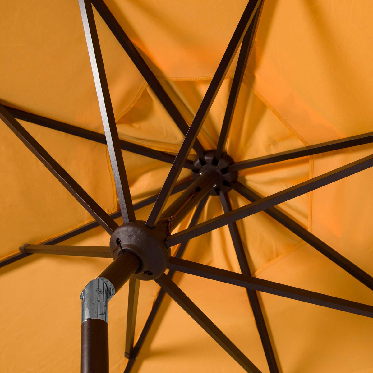 Brown metal ribs radiate beneath the golden yellow canopy from a central support hub.