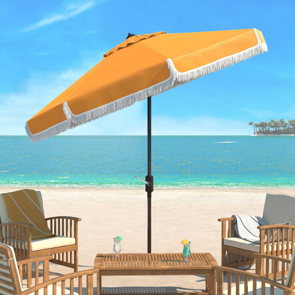 A tilted yellow umbrella brings white-fringed shade to patio seating by the sea.