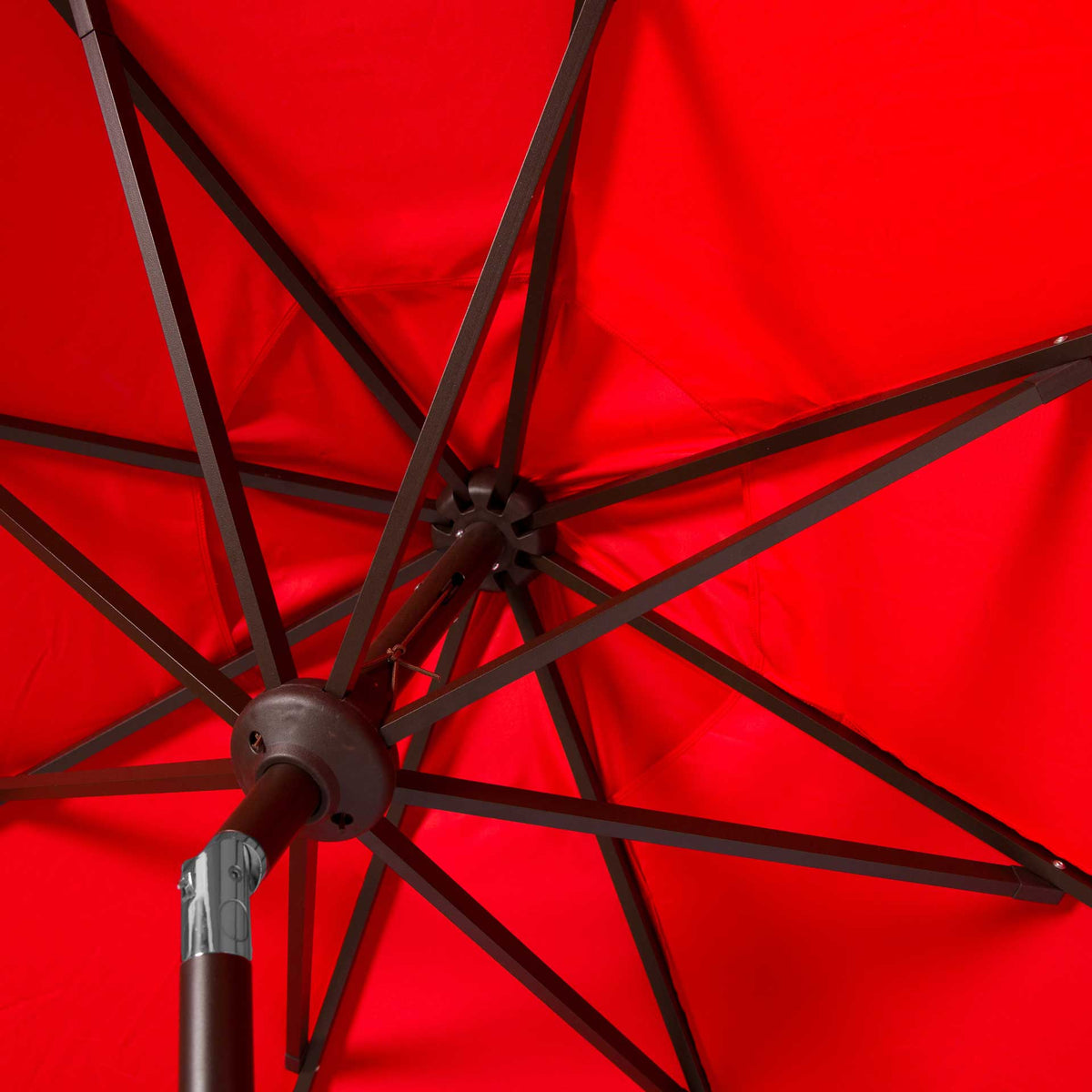 A dark brown rib framework supports the red fabric canopy from its central hub.