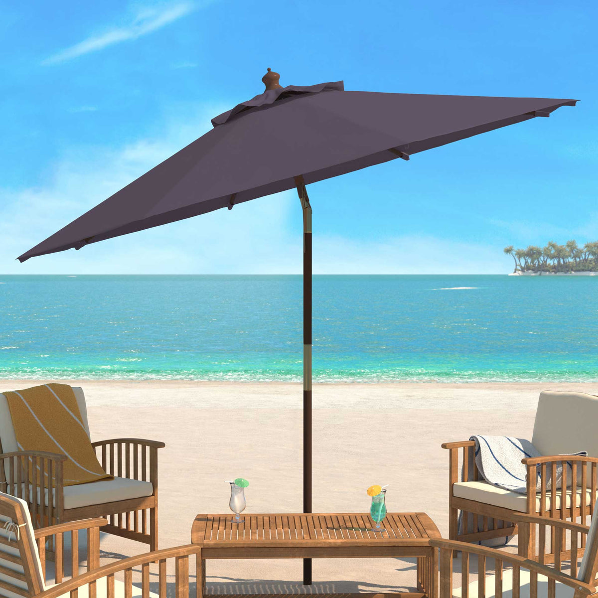 A gray umbrella provides seaside shade for a wood table and cushioned chairs