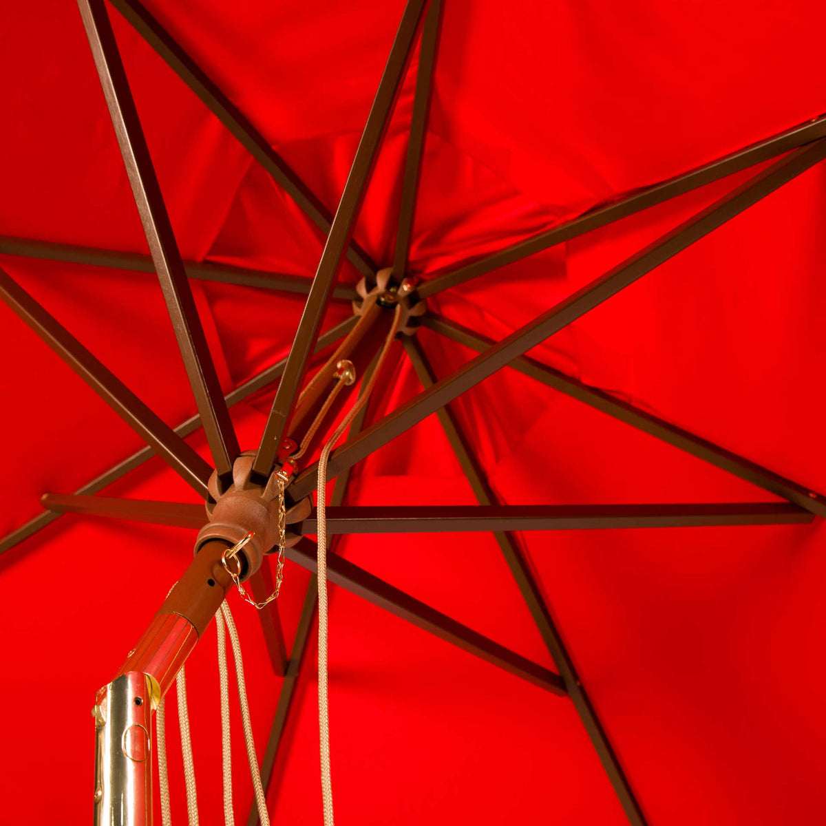 Wooden ribs and brass-tone fittings stand out against the bright red canopy