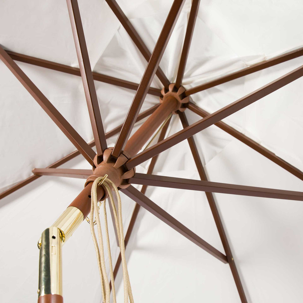 Ivory fabric surrounds wooden support ribs, hanging cords, and brass-tone hardware