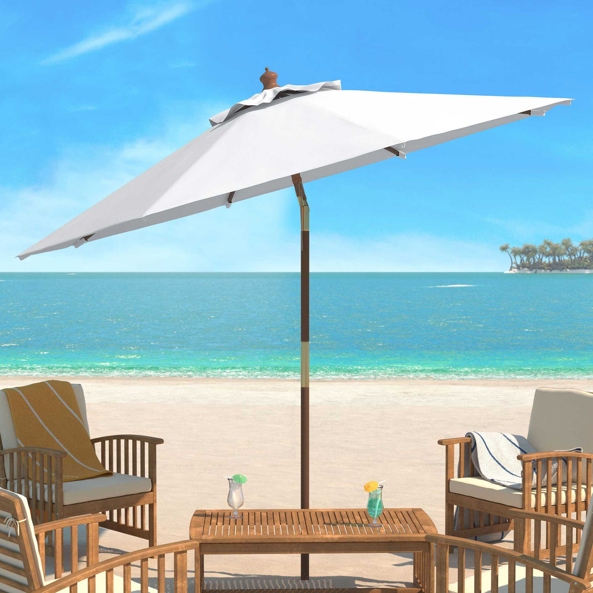 A crisp ivory umbrella shades a slatted wood table and chairs by the shore