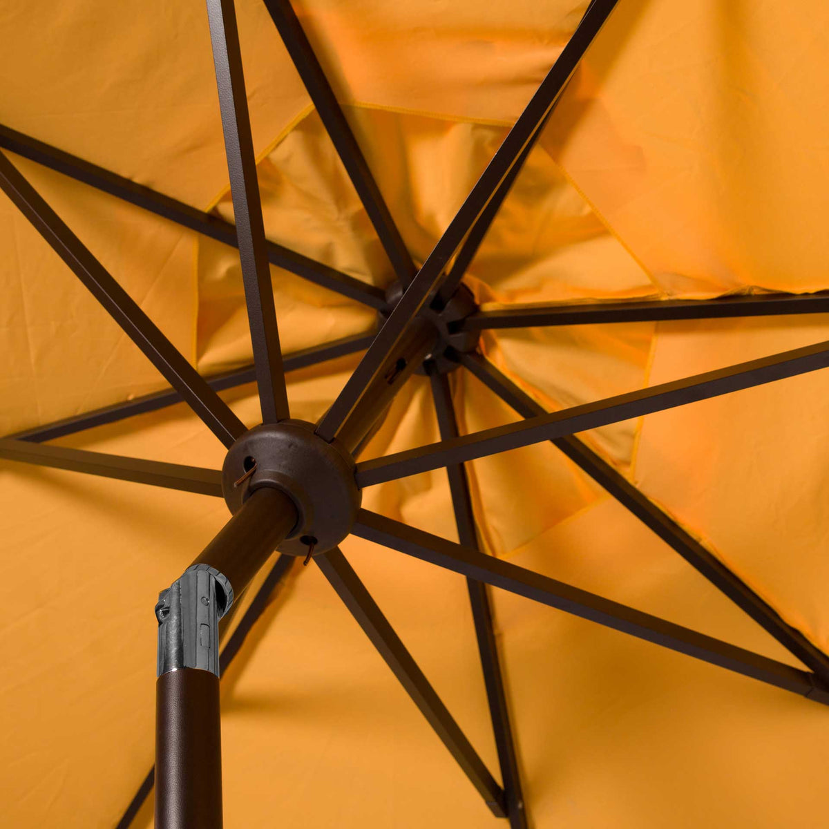 Brown ribs spread beneath the golden yellow canopy, meeting at a sturdy center hub