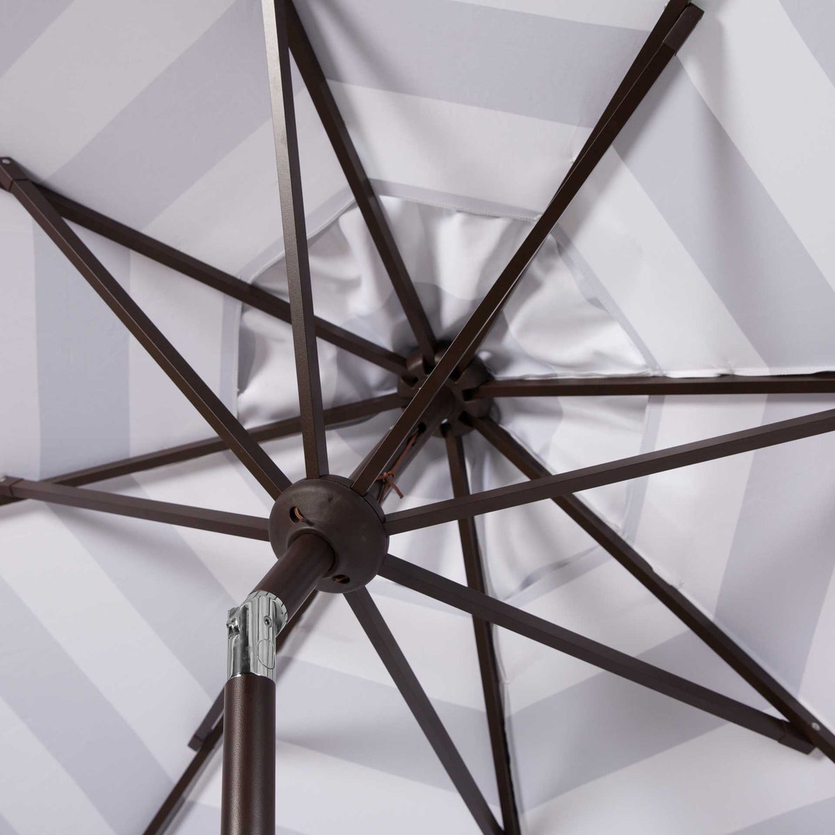 Brown support ribs spread beneath the gray and white canopy beside a silver tilt joint